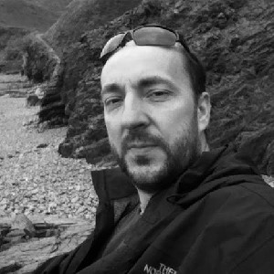 Black and white picture of Mike sitting on a beach